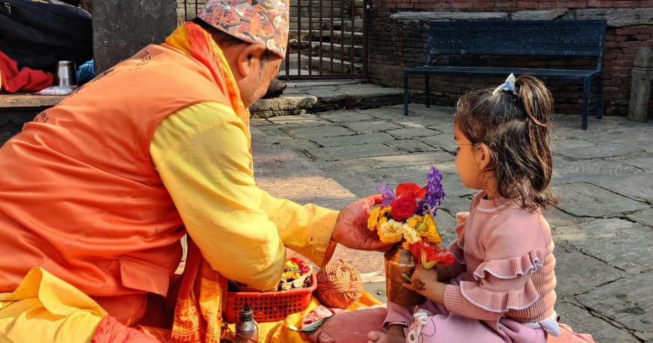 Nepalese hospitality with flowers, and a brahman interacting with a Nepalese girl