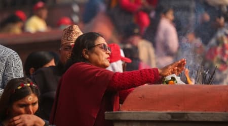 Spirituality is everywhere in Nepal, a woman is offering to the gods at a small shrine
